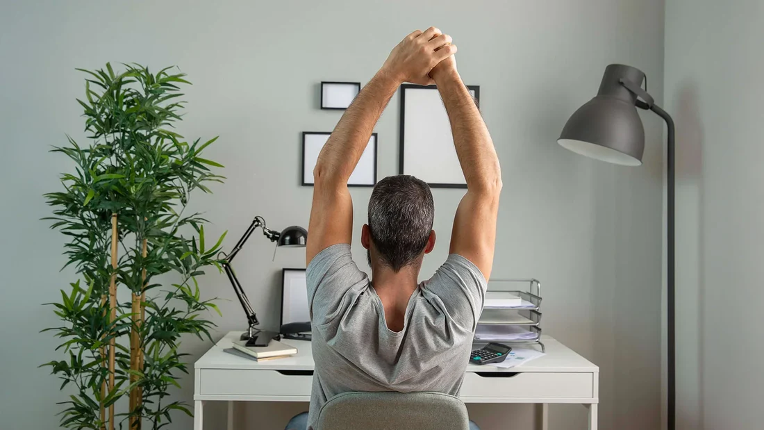 Person doing desk stretches in office environment